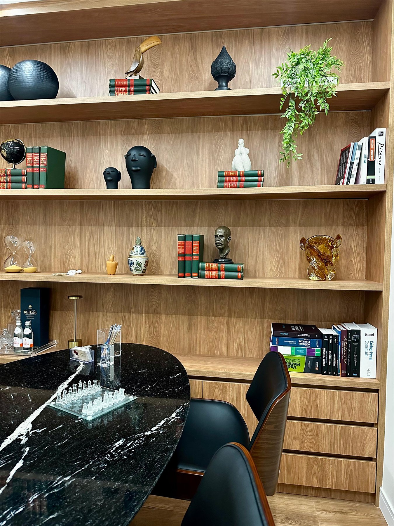 Sala do escritório com estante de livros e mesa de reunião